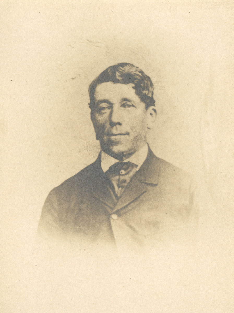 Historic image of an adult white male from the 1800s wearing a formal jacket and shirt.
