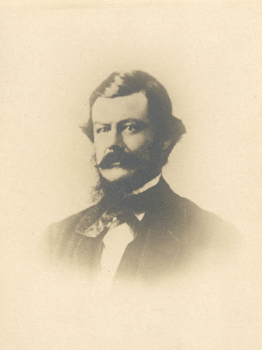 Historic image of an adult white male from the 1800s wearing a formal jacket and shirt.