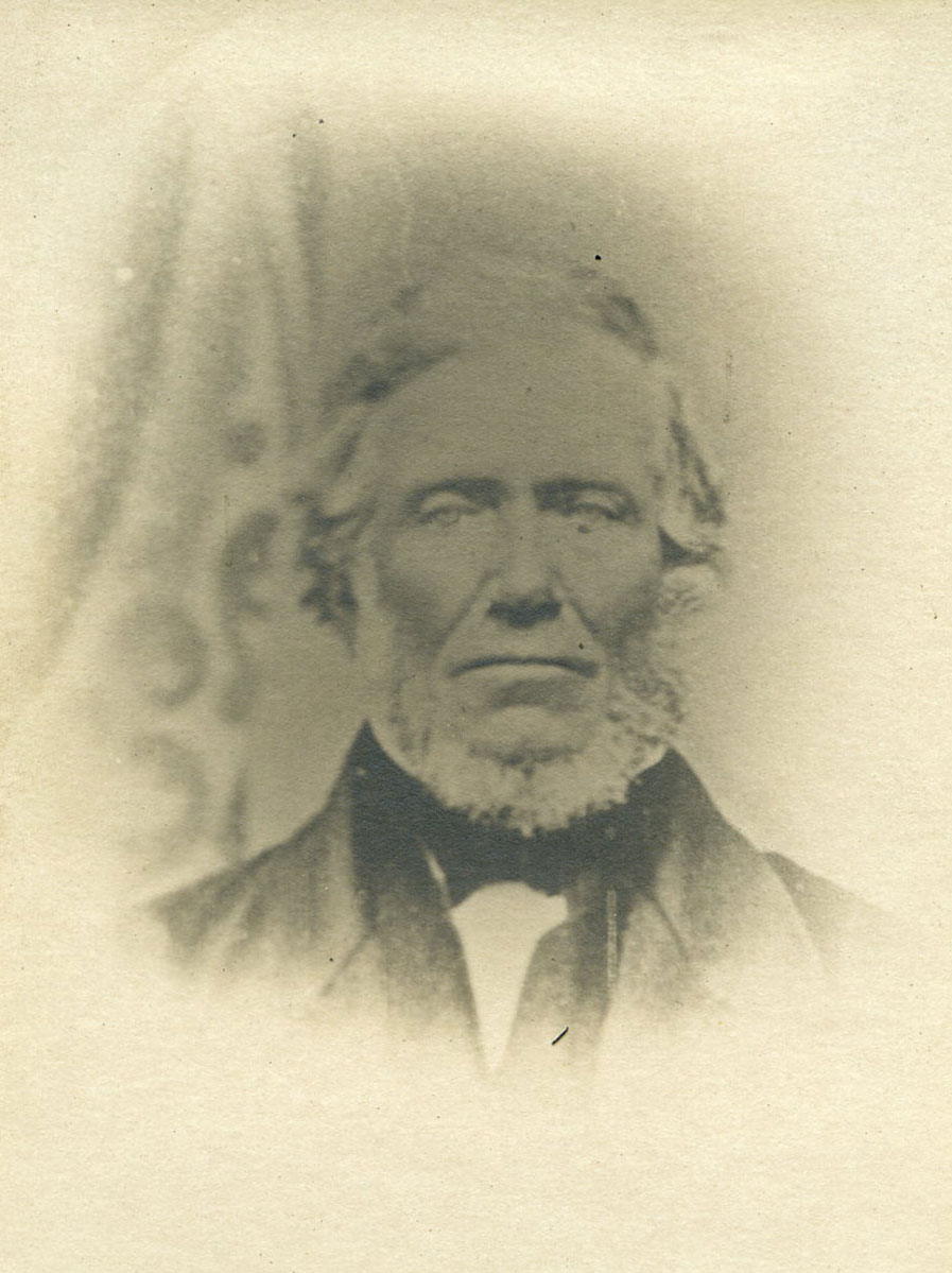 Historic image of an adult white male from the 1800s wearing a formal jacket and shirt.