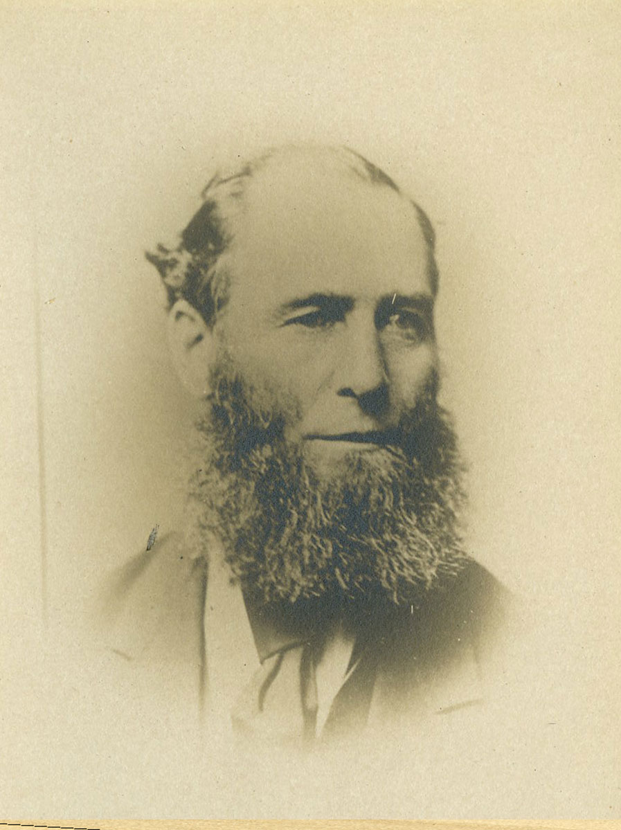 Historic image of an adult white male from the 1800s wearing a formal jacket and shirt.