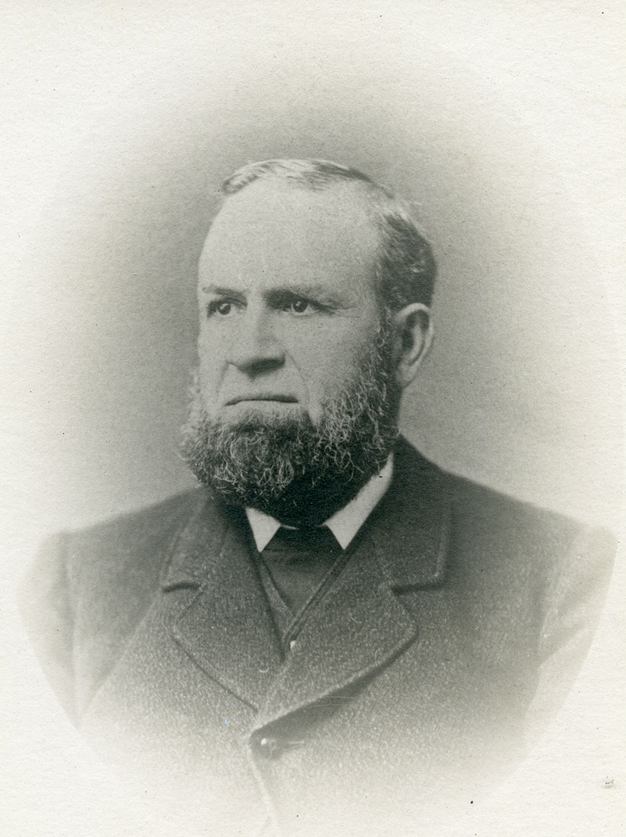 Historic image of an adult white male from the 1800s wearing a formal jacket and shirt.
