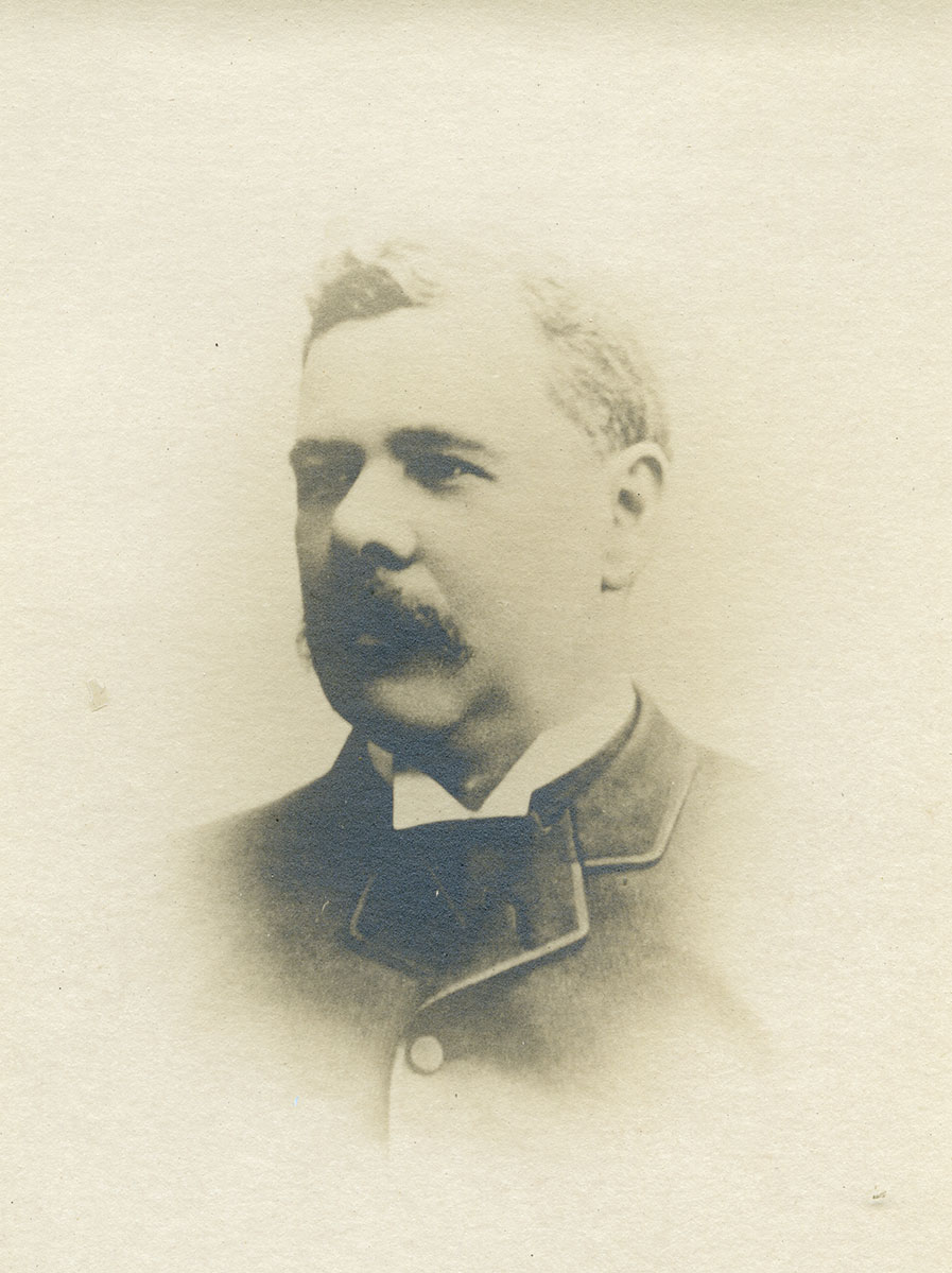 Historic image of an adult white male from the 1800s wearing a formal jacket and shirt.
