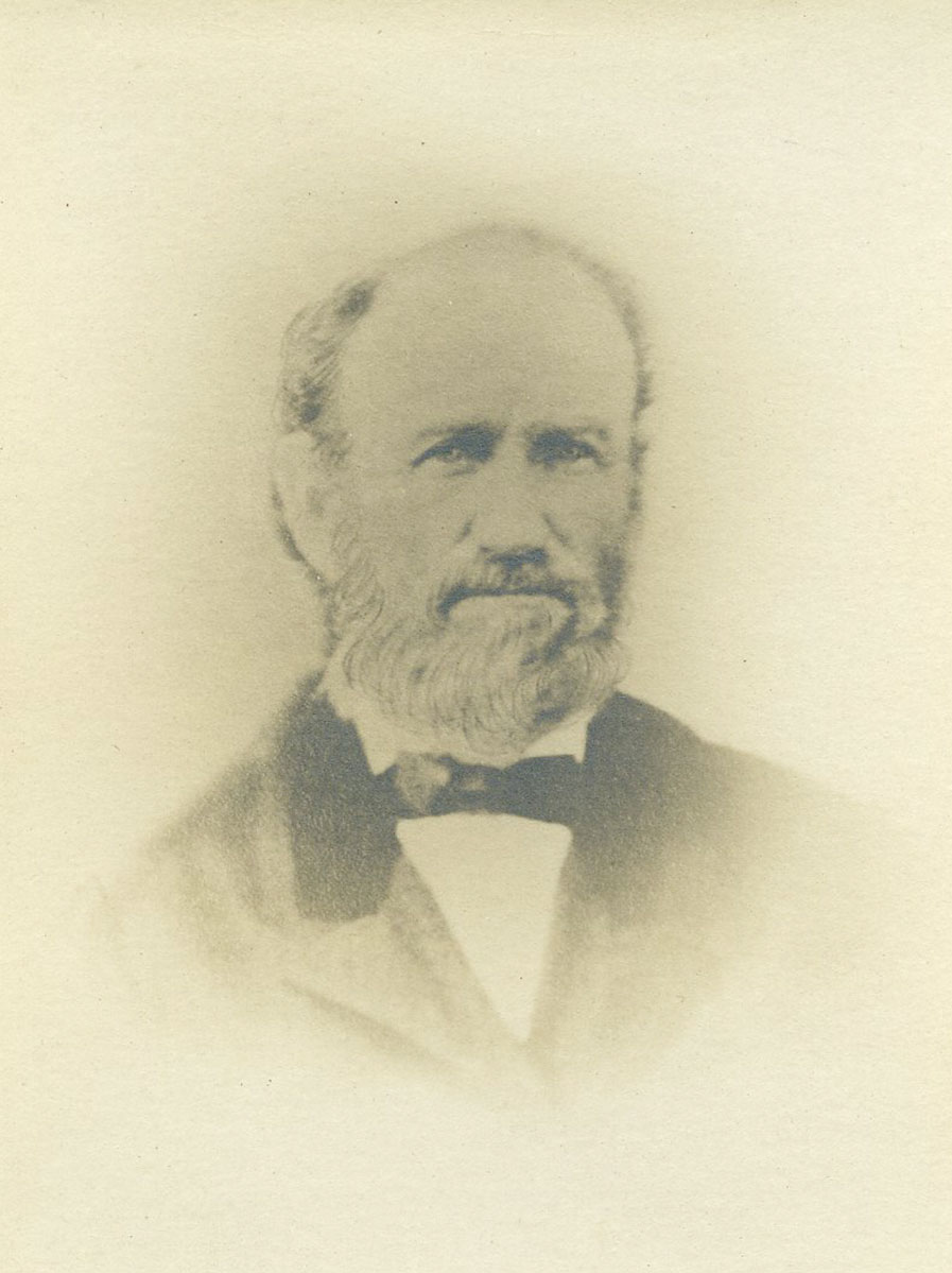 Historic image of an adult white male from the 1800s wearing a formal jacket and shirt.