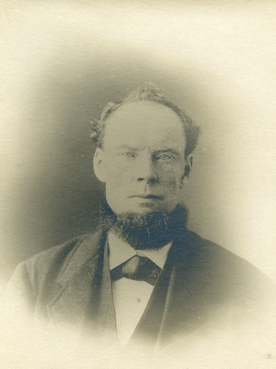 Historic image of an adult white male from the 1800s wearing a formal jacket and shirt.