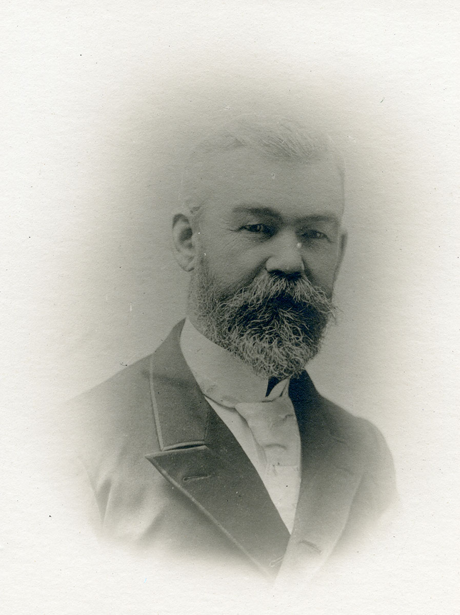 Historic image of an adult white male from the 1800s wearing a formal jacket and shirt.