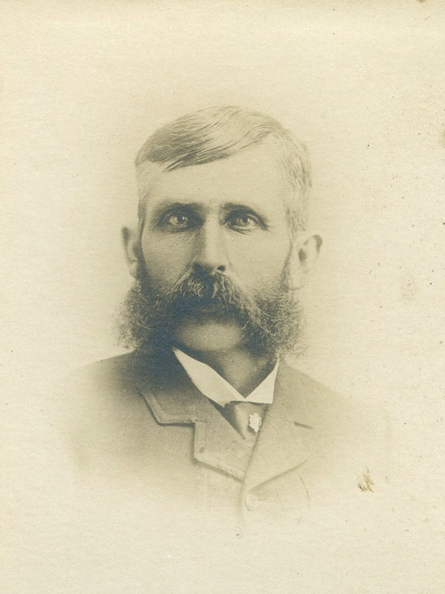 Historic image of an adult white male from the 1800s wearing a formal jacket and shirt.
