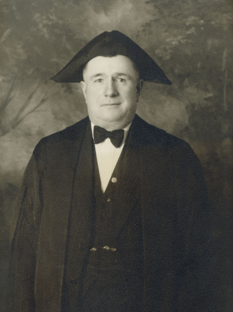 Historic image of an adult white male from the early 1900s wearing a formal jacket and shirt.