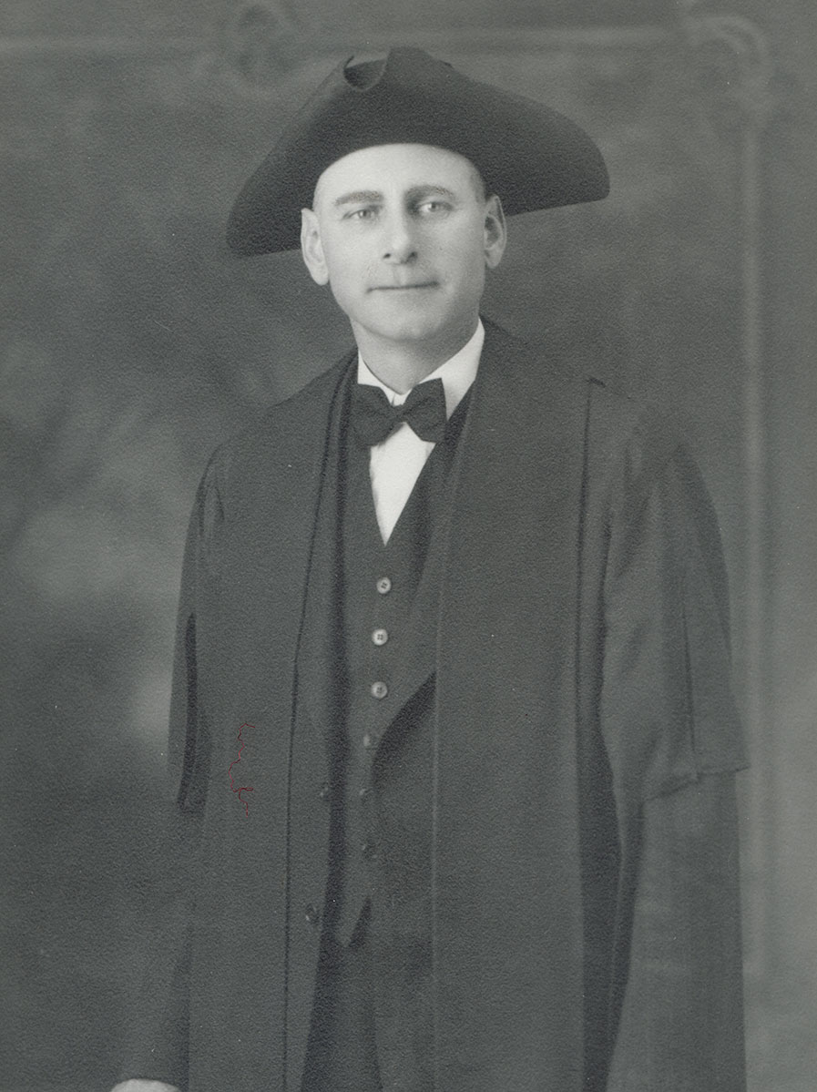 Historic image of an adult white male from the early 1900s wearing a formal jacket and shirt.