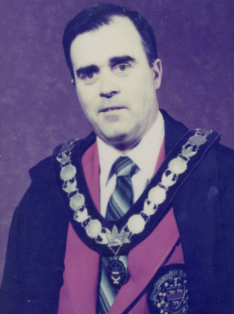 Photo of man in a suit and warden medal.