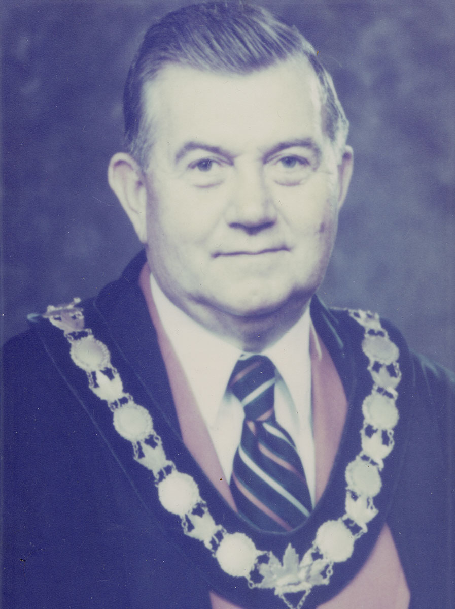 Photo of man in a suit and warden medal.