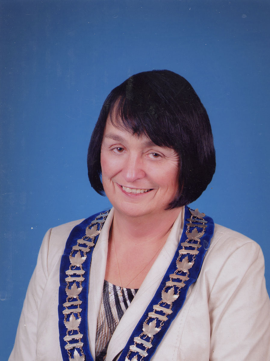 Photo of woman in a suit and warden medal.