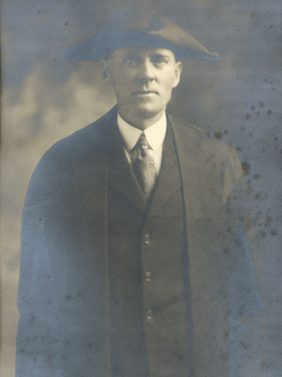Historic image of an adult white male from the early 1900s wearing a formal jacket and shirt.