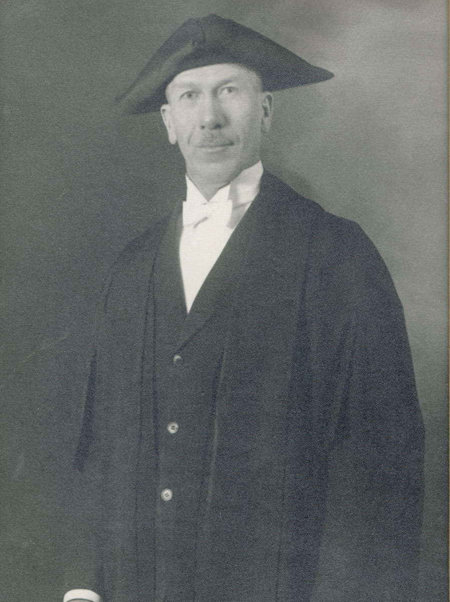 Historic image of an adult white male from the early 1900s wearing a formal jacket and shirt.