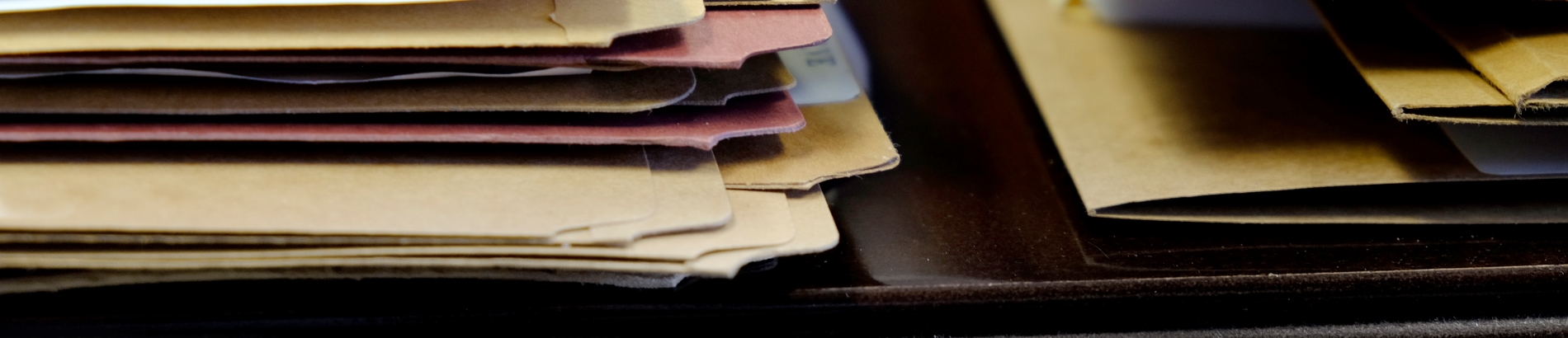 stack of folders and files containing paper documents