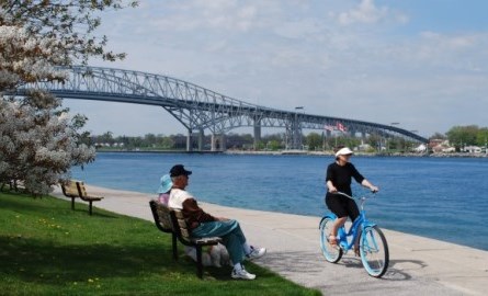 Person riding bike along waterfront with Bluewater Bridge in background