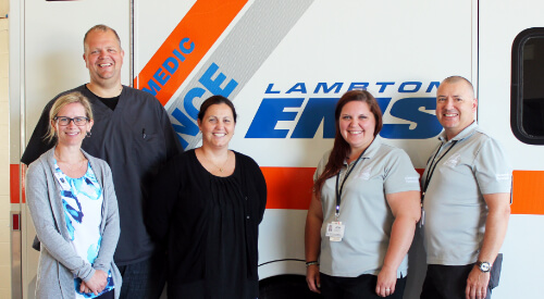 Paramedics in front of an ambulance smiling