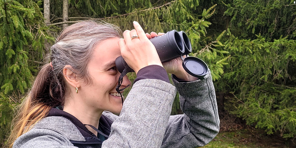 Vanitia Campbell, Public Services Coordinator – Youth, uses binoculars from one of the new kits available for loan from Lambton County Library.