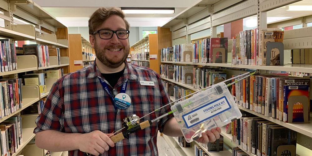 Grant Richard from Lambton County Library holds one of the fishing pole kits available to borrow from the library.