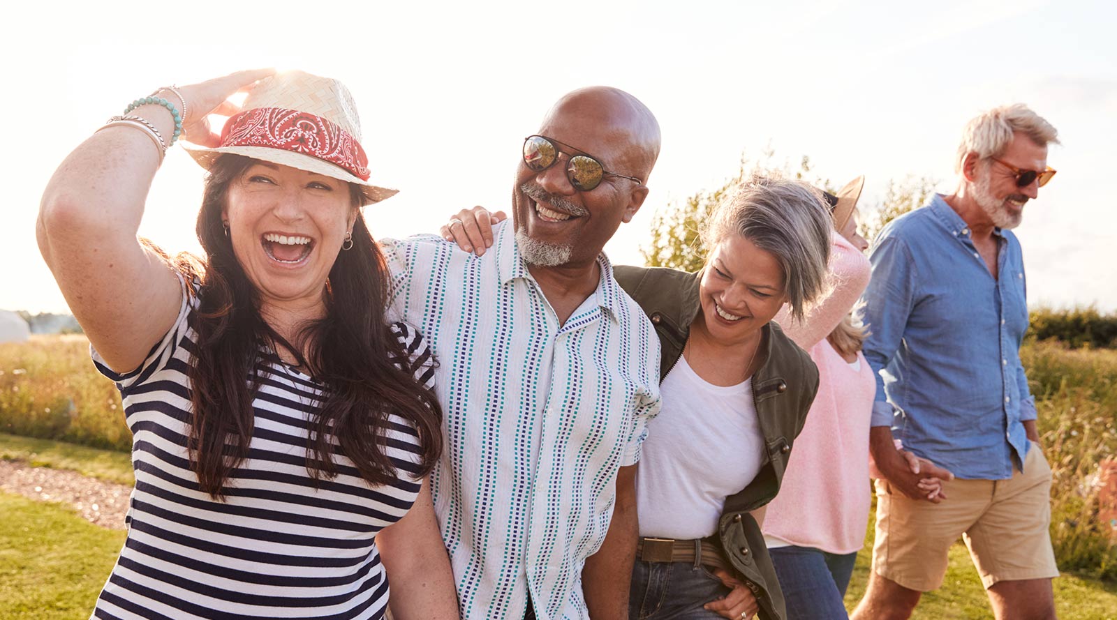 group of mature friends walking through field