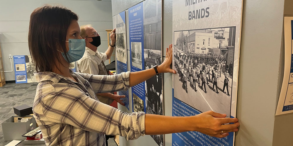 Archivist, Nicole Aszalos of Lambton County Archives installs exhibit with Don Vander Klok from the Lambton Concert Band