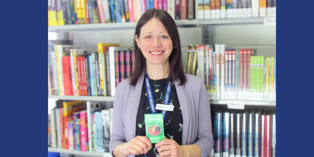 Adrianne Lebert, Public Services Coordinator– Adult Programs & Outreach, displays a One Seed Lambton tomato seed packet.