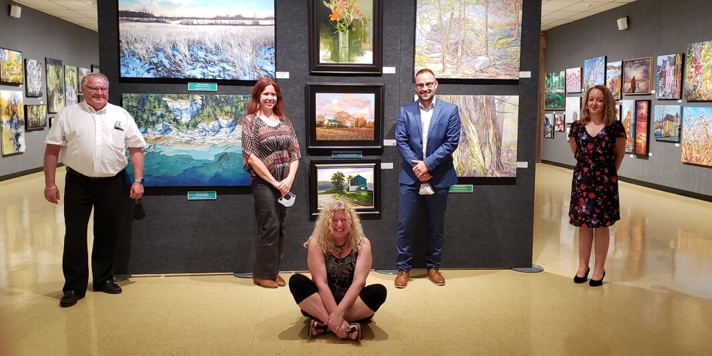 Warden Weber and staff from the County of Lambton and Grand Bend Art Centre standing in front of the Paint Ontario exhibit space