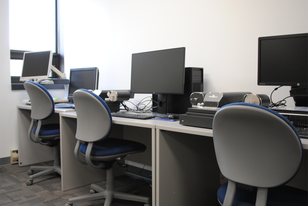 empty chairs sitting in front of computer stations