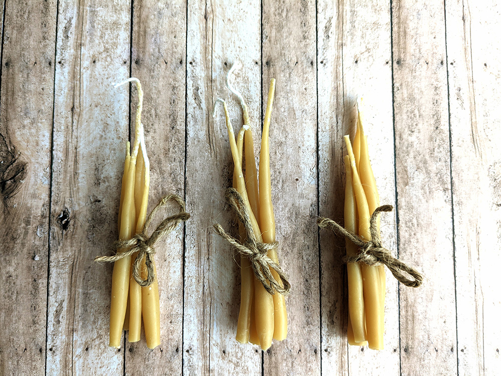 Bundles of wax candles on wooden surface