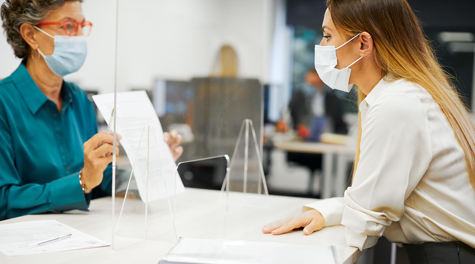 Woman checking a customer's vaccination receipt