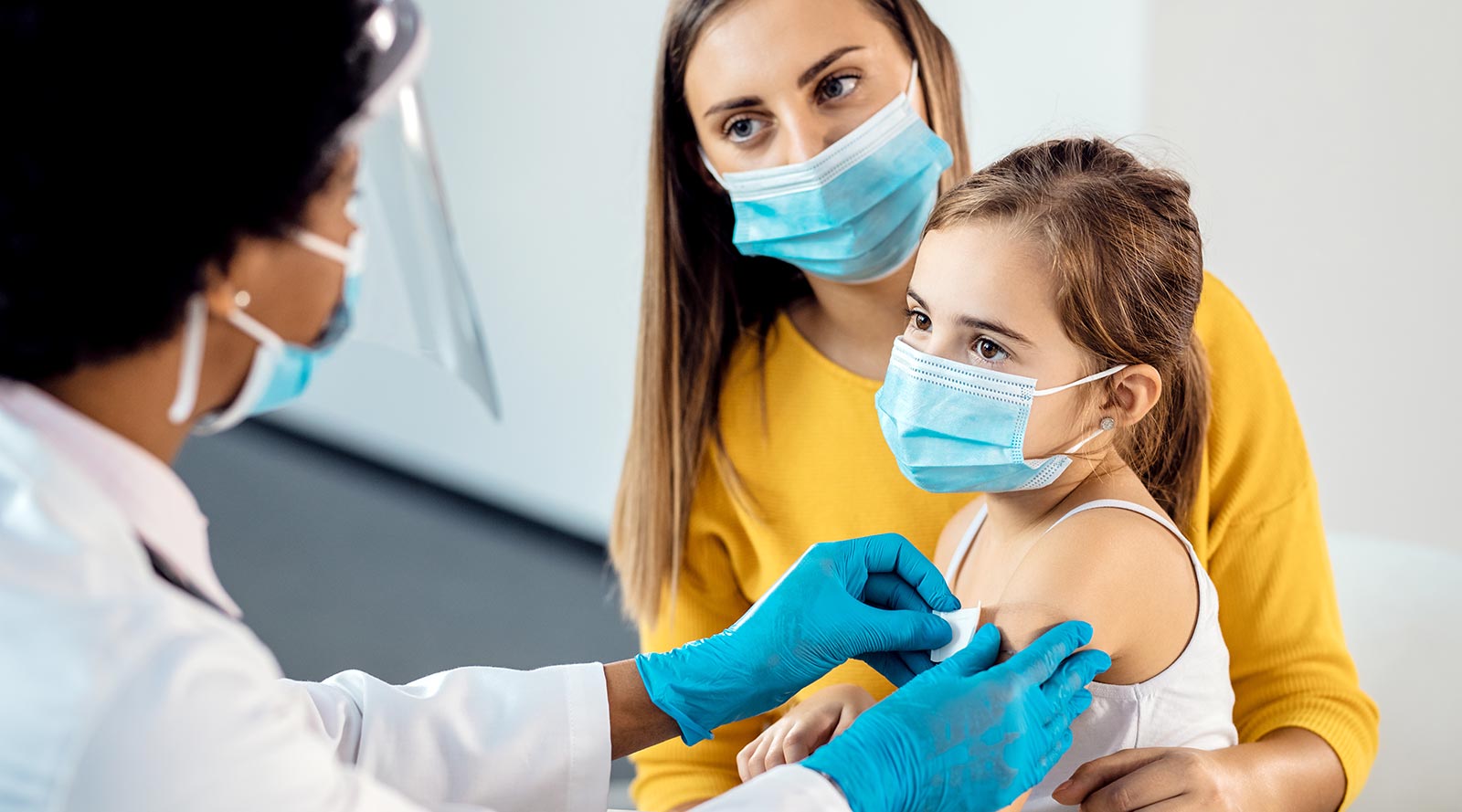 Child sitting on parents lap after receiving vaccine.