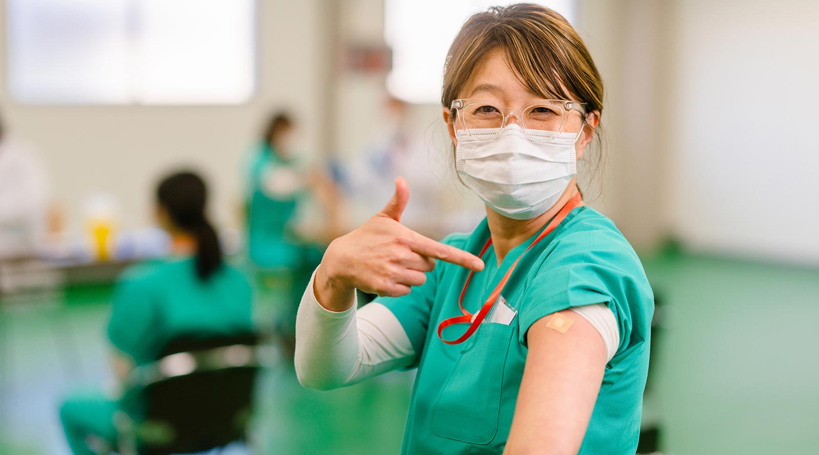 Nurse pointing to arm after receiving vaccination