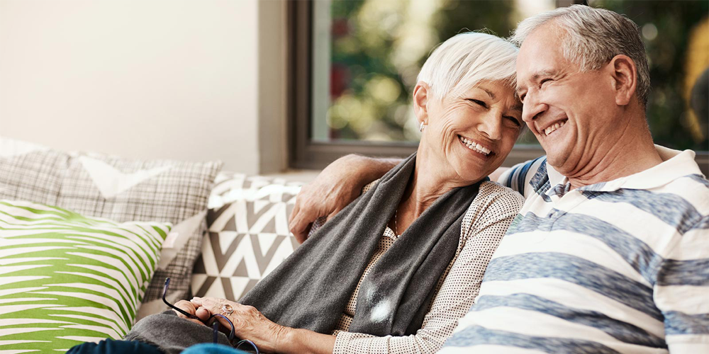 Senior man and woman sitting on couch