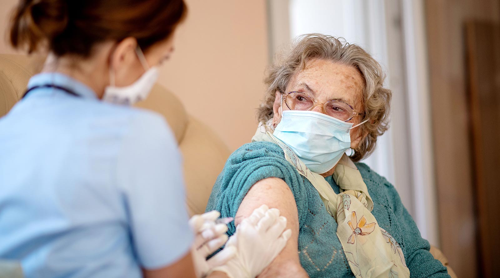 Senior receives a vaccine from a nurse