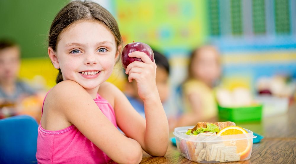 Student in a classroom eating an apple